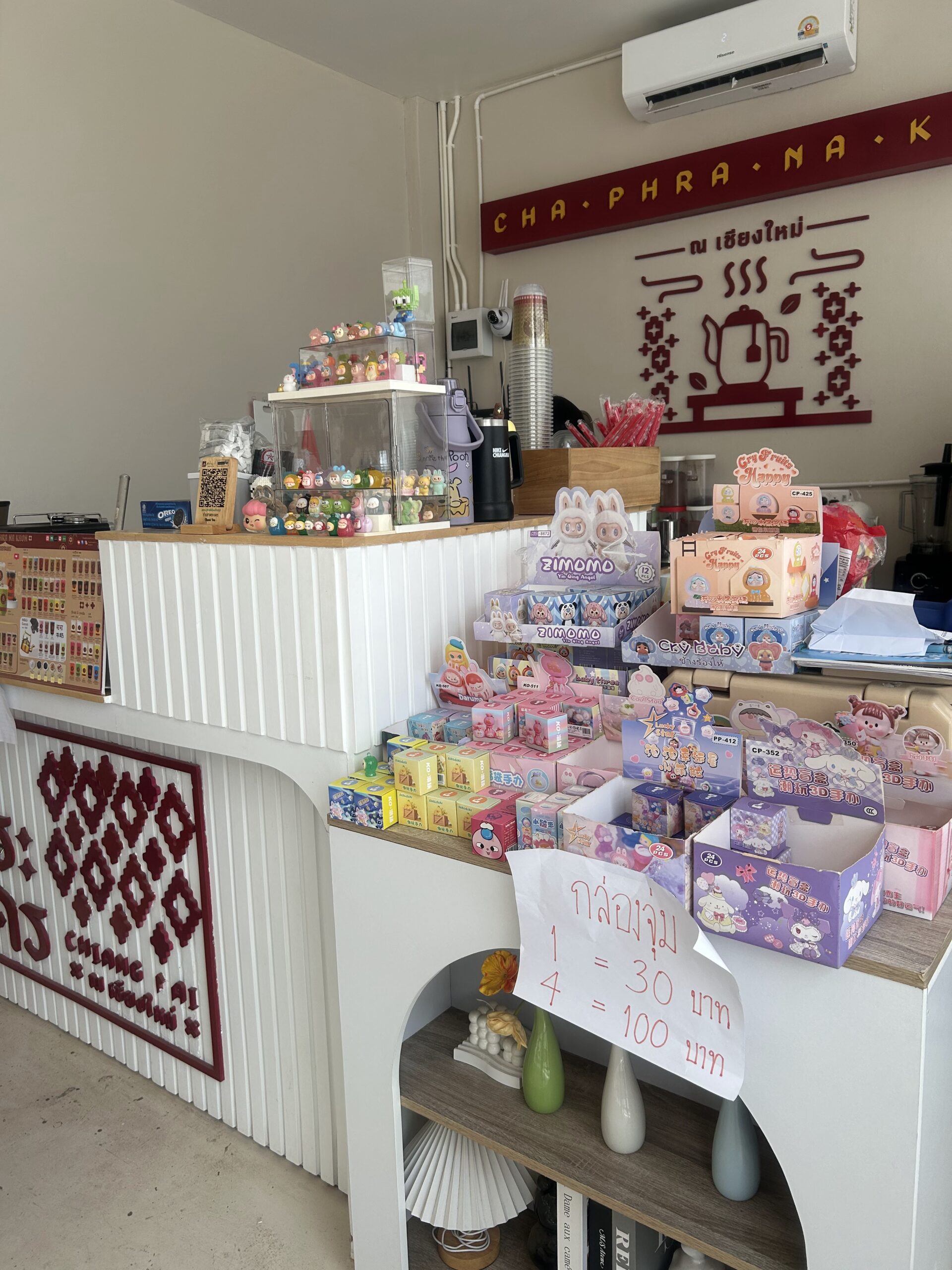 เคาน์เตอร์ร้านชาพระนค ณ เชียงใหม่ ตกแต่งด้วยตุ๊กตาฟิกเกอร์และกล่องสุ่มขาย 1 ชิ้น 30 บาท 4 ชิ้น 100 บาท