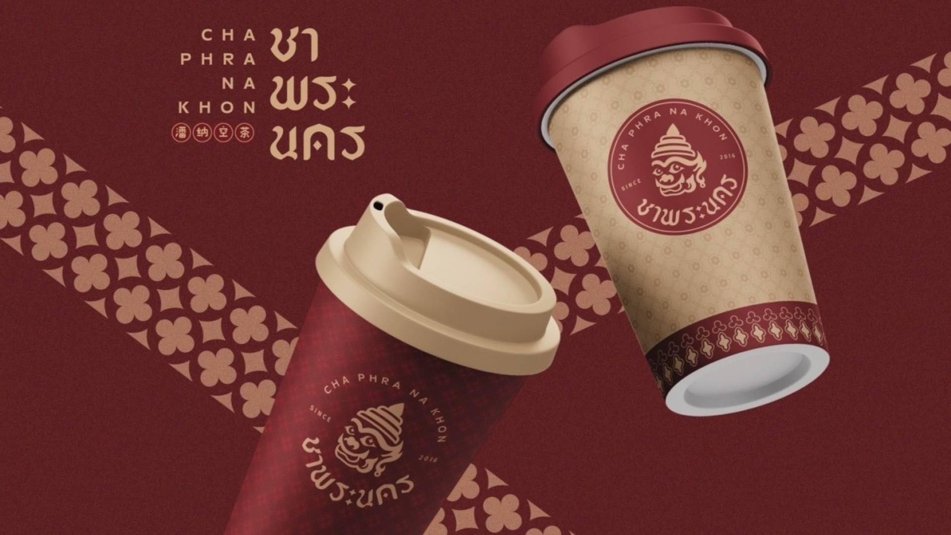 แก้วกาแฟแบรนด์ชาพระนคร ดีไซน์สีแดงเข้มและสีทองพร้อมโลโก้หัวยักษ์สไตล์ไทย