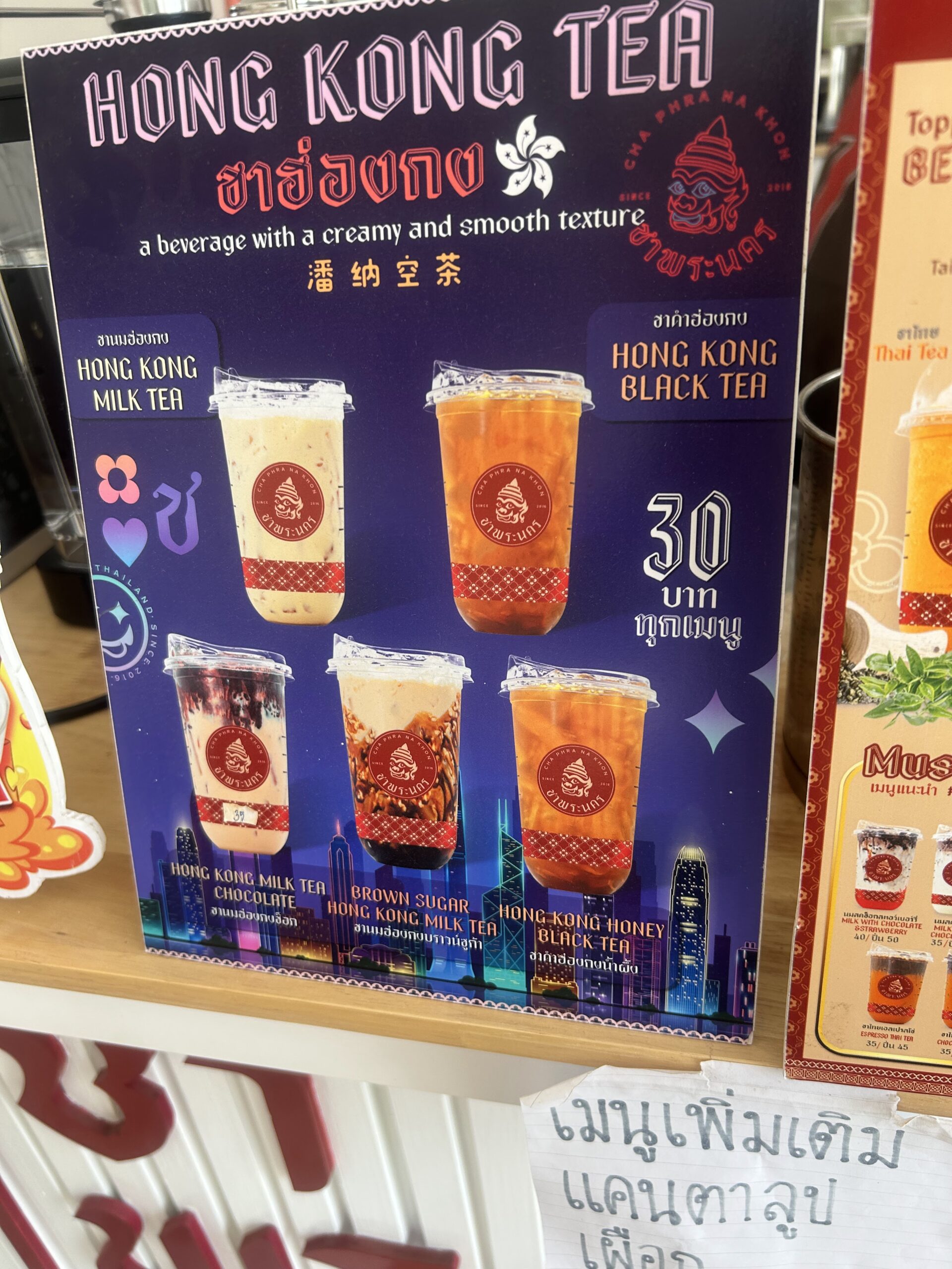 ป้ายเมนูชาฮ่องกงแสดงชานมฮ่องกง ชาดำฮ่องกง ชานมช็อกโกแลต ชานมบราวน์ชูการ์ และชาดำน้ำผึ้ง ราคา 30 บาททุกเมนู