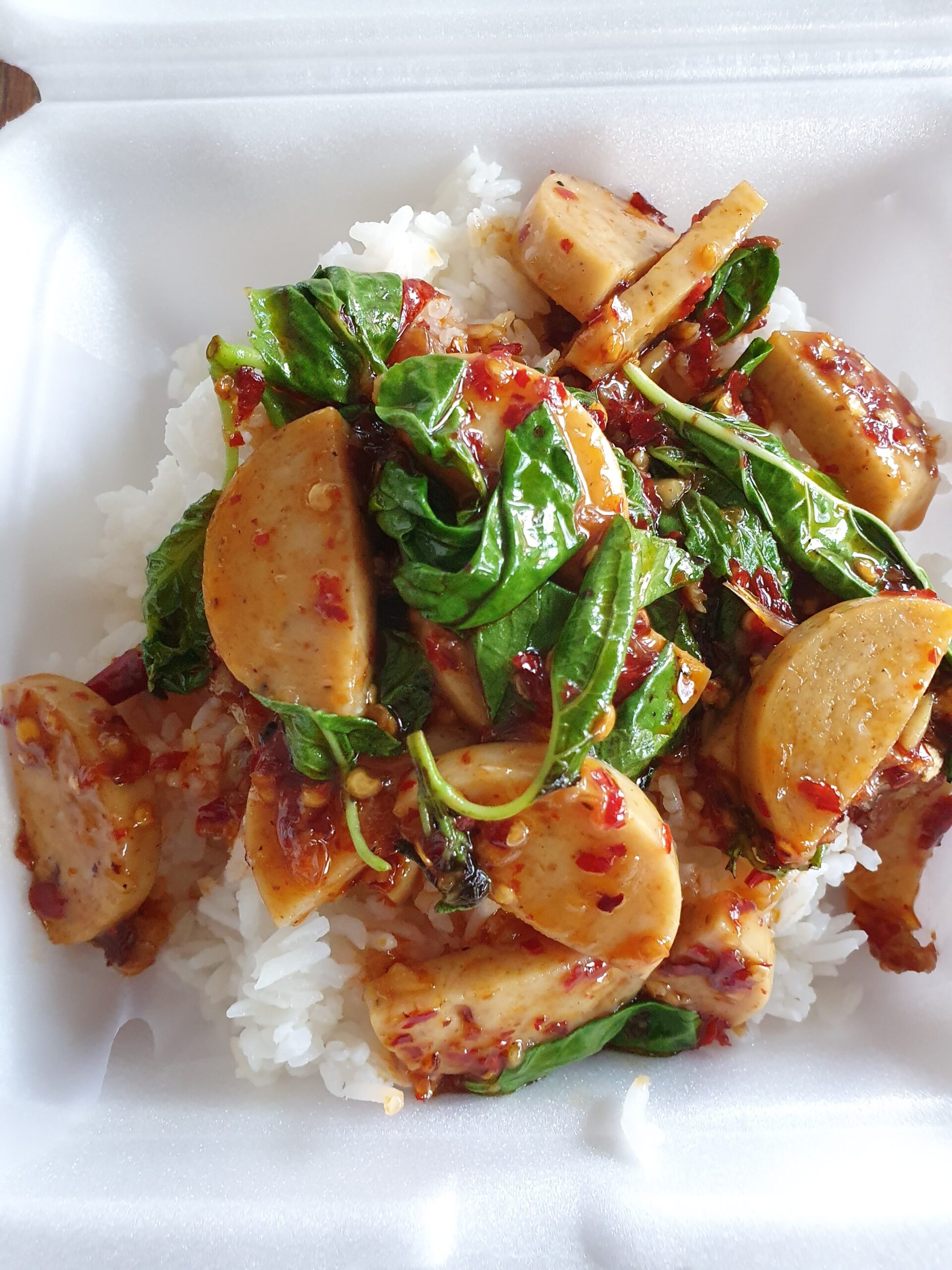 ข้าวราดกุนเชียงผัดกะเพราพริกแห้ง ในกล่องโฟมสีขาว