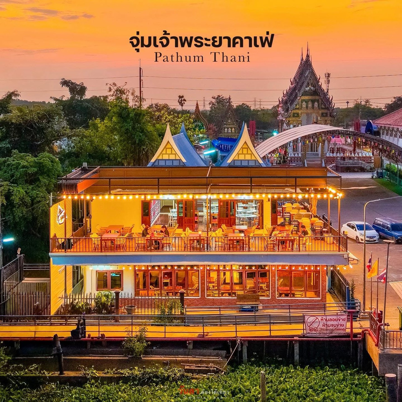 จุ่มเจ้าพระยาคาเฟ่ ร้านอาหารริมแม่น้ำเจ้าพระยา ปทุมธานี อาคารสองชั้นสีเหลืองสวยงามยามพระอาทิตย์ตก มีวัดเป็นฉากหลัง