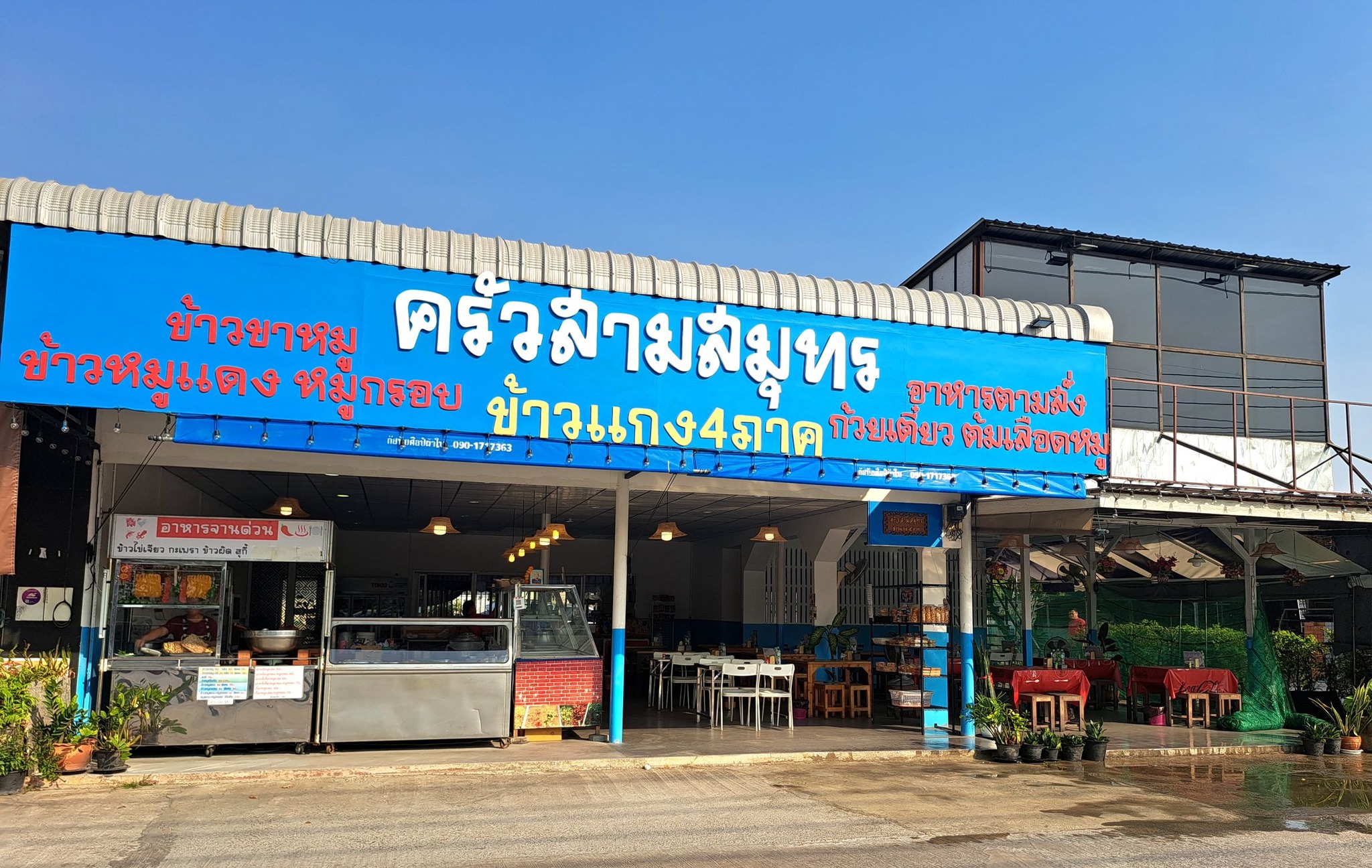 ร้านครัวสามสมุทร ร้านอาหารไทยมีป้ายสีฟ้าขนาดใหญ่ เสิร์ฟข้าวแกง 4 ภาค ข้าวขาหมู ข้าวหมูแดง หมูกรอบ ก๋วยเตี๋ยว และอาหารตามสั่ง