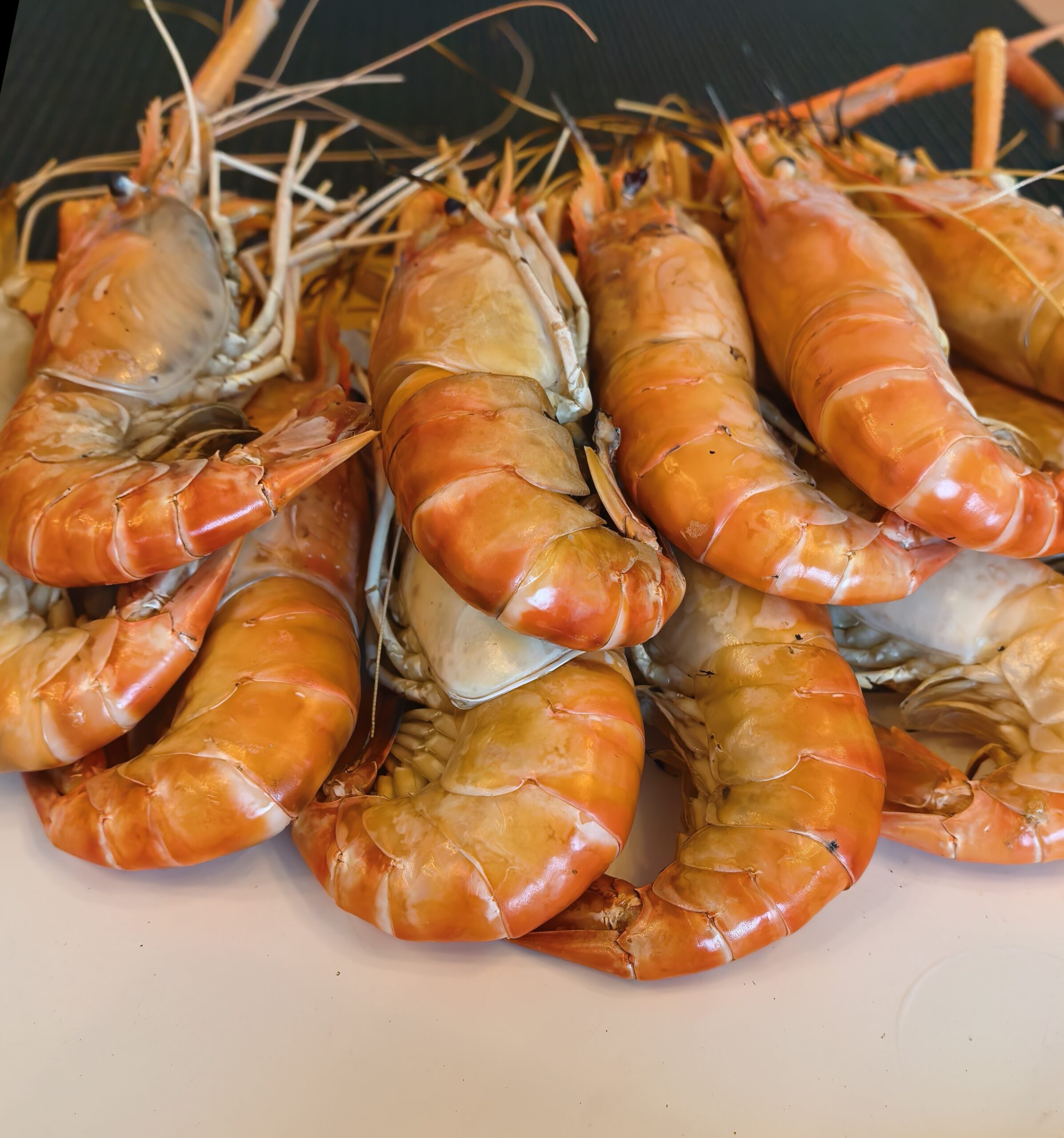 กุ้งแม่น้ำตัวใหญ่ต้มสุกสีส้มสดใสวางเรียงกันบนจาน