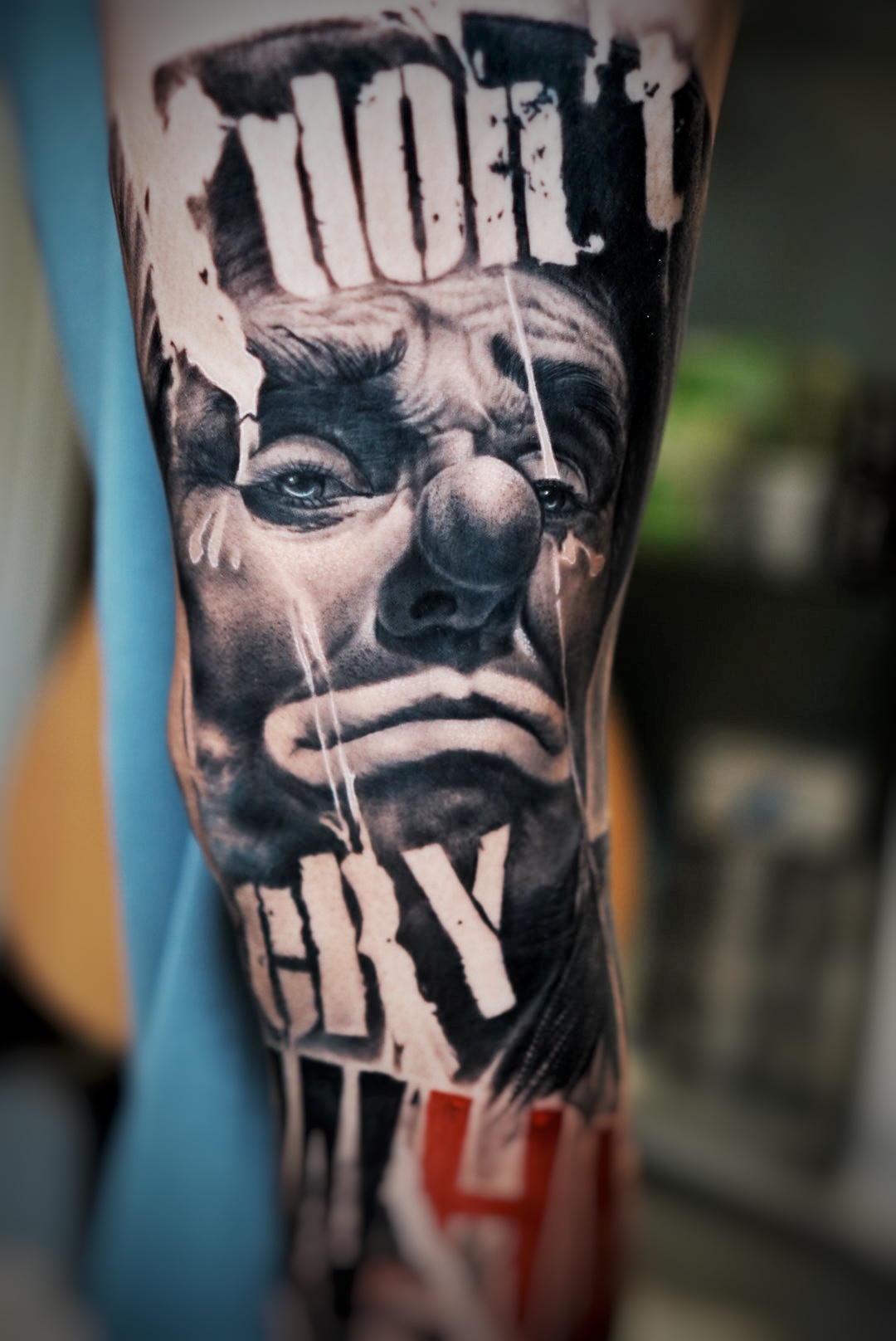 รอยสักรูปหน้าตัวตลกที่กำลังร้องไห้บนแขน พร้อมข้อความว่า Don't Cry