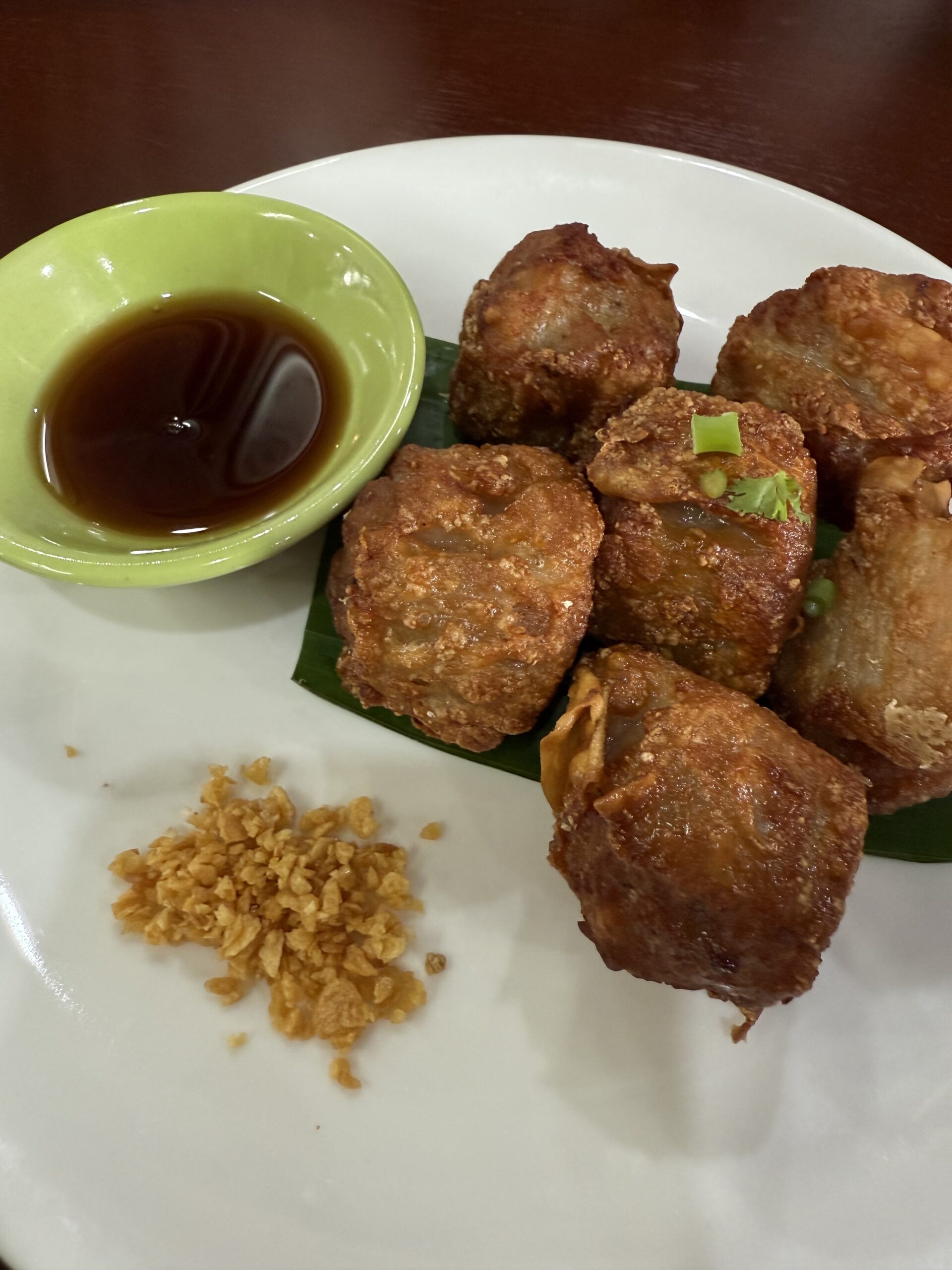 เกี๊ยวทอดกรอบเสิร์ฟบนใบตองพร้อมซอสจิ้มและกระเทียมเจียว