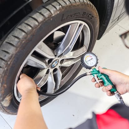 มือกำลังใช้เกจวัดแรงดันลมยางตรวจสอบลมยางรถยนต์ที่มีล้อแม็กซ์ BMW