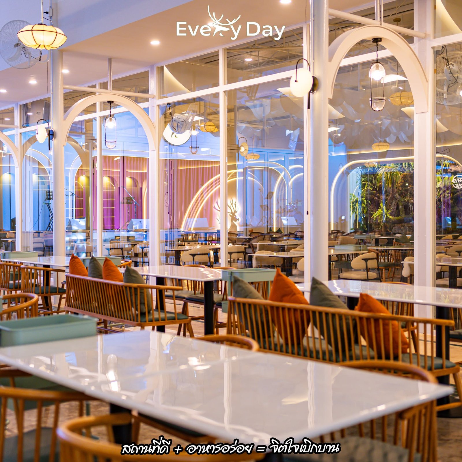 บรรยากาศภายในร้าน Every Day ตกแต่งสไตล์โมเดิร์นด้วยซุ้มโค้งสีขาว กระจกใส โคมไฟสวยงาม โต๊ะไม้พร้อมหมอนอิงสีส้ม