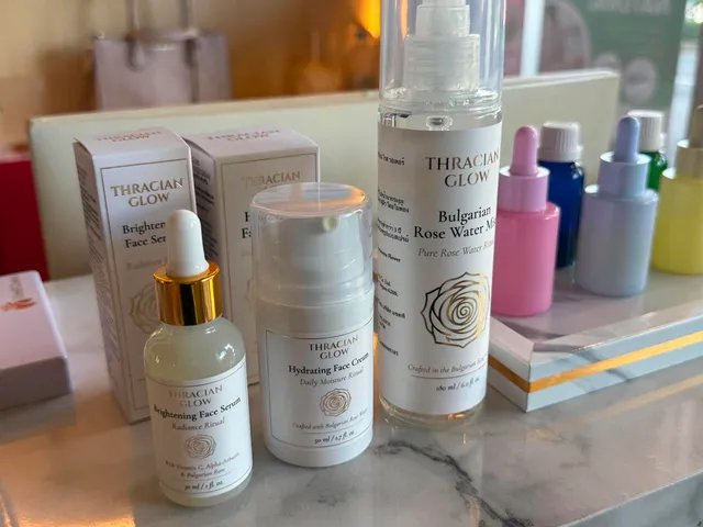 ผลิตภัณฑ์ดูแลผิว Thracian Glow รวมถึงเซรั่มเพิ่มความสว่าง ครีมบำรุงผิวหน้า และสเปรย์น้ำกุหลาบบัลแกเรีย วางเรียงบนโต๊ะหินอ่อน